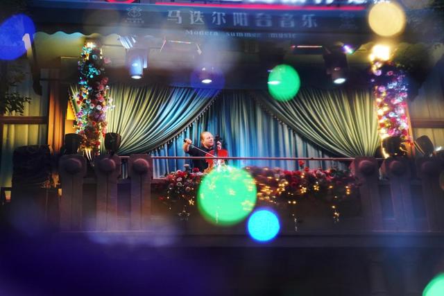 在哈尔滨中央大街的马迭尔阳台音乐会上，一位外国演员在演奏。新华社记者 王建威 摄